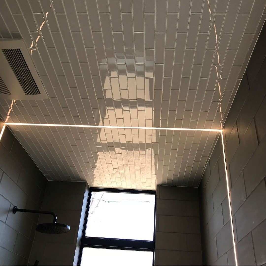 Curbless schluter shower pan with linear drain. Glass tile on offset